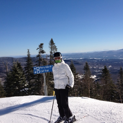 Hannah on skis at top of mountain